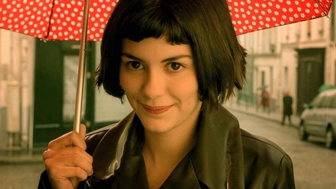 Mulher sorrindo e segurando um guarda-chuva